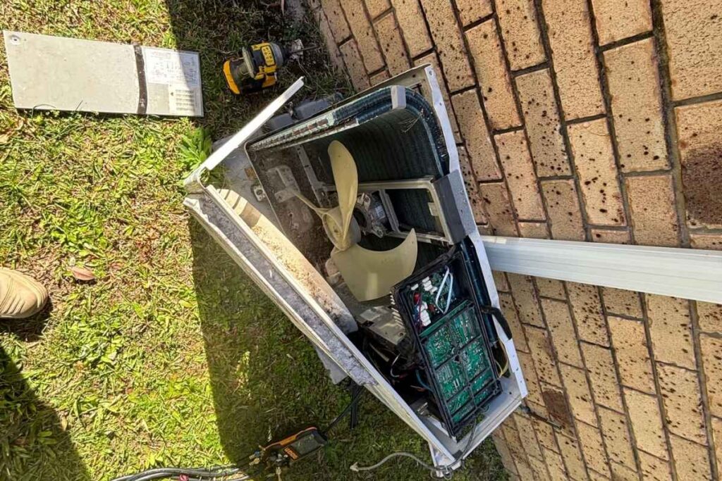Outdoor AC unit opened during a residential air conditioning Gold Coast service, control board exposed to check for aircon faults