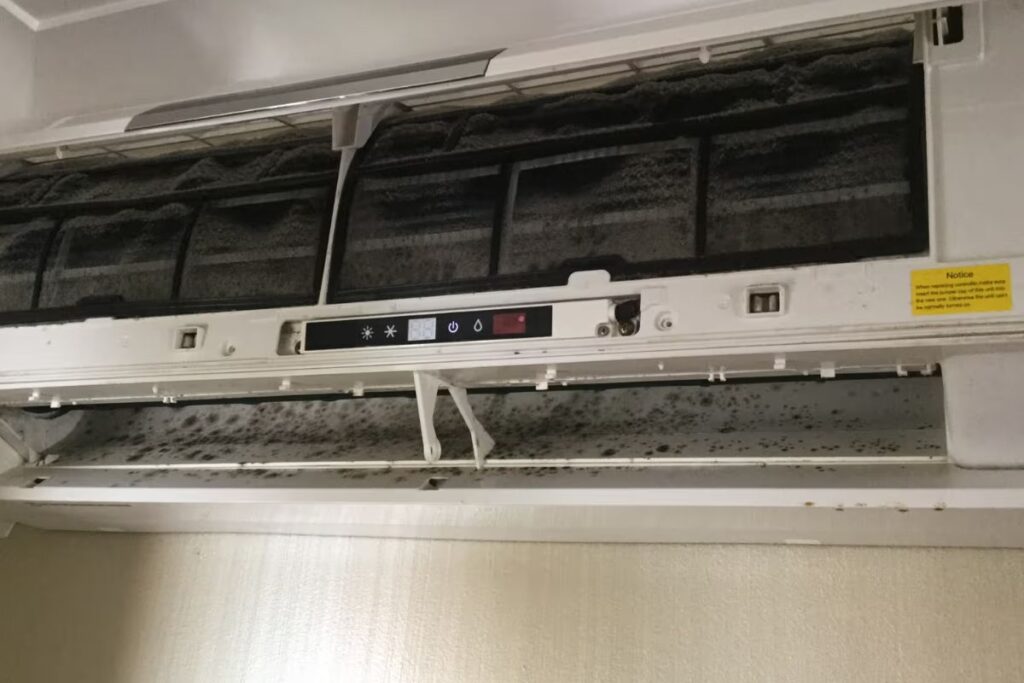 An open split system unit with heavy dust and mould accumulation needing a professional air conditioning service Gold Coast in Burleigh Heads.