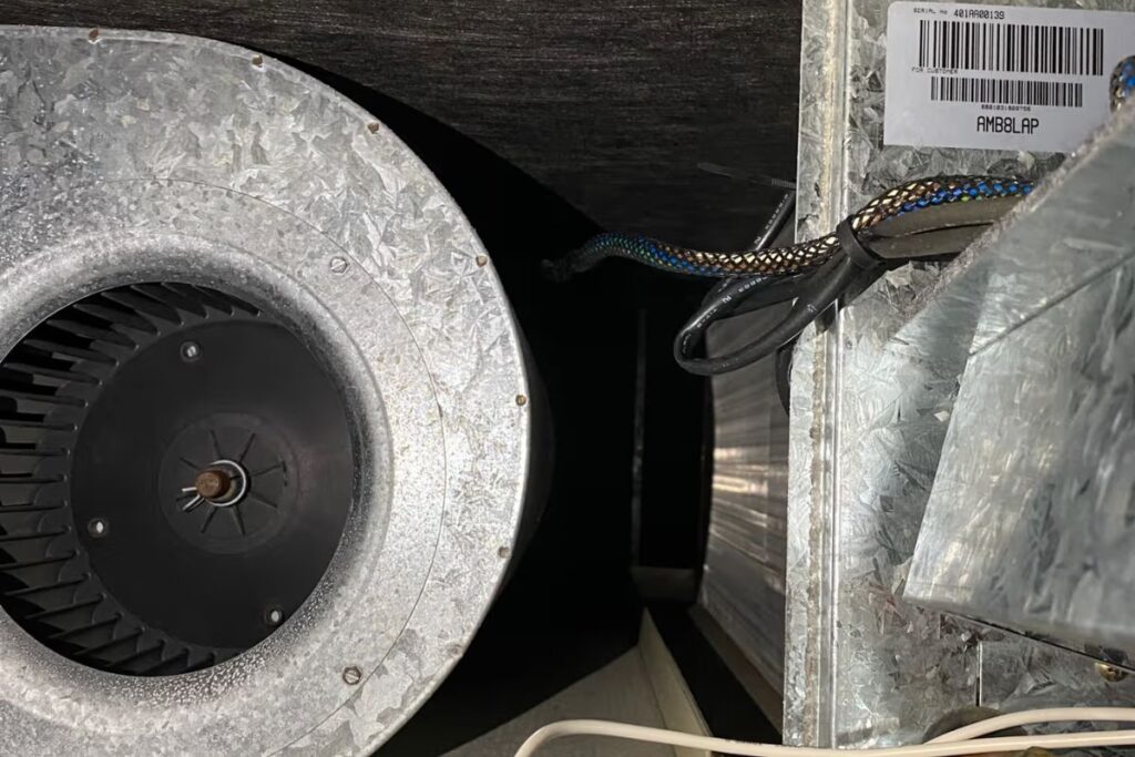Close-up of an indoor blower fan motor, a common source of an aircon burning motor smell