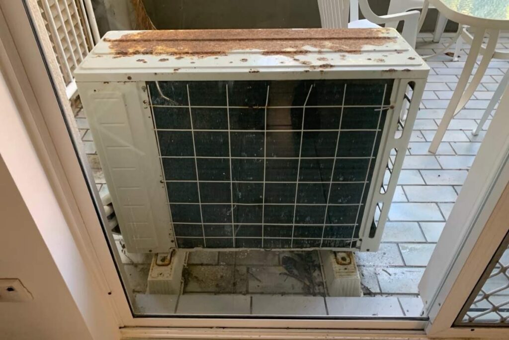 Rusty outdoor air conditioning unit on a Gold Coast balcony, showing salt-air corrosion from skipped air conditioning maintenance.