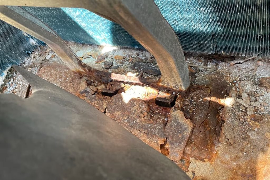 Corroded fan bracket and coil base in a beachside unit — a case for a proper air conditioning Gold Coast installation near the beach