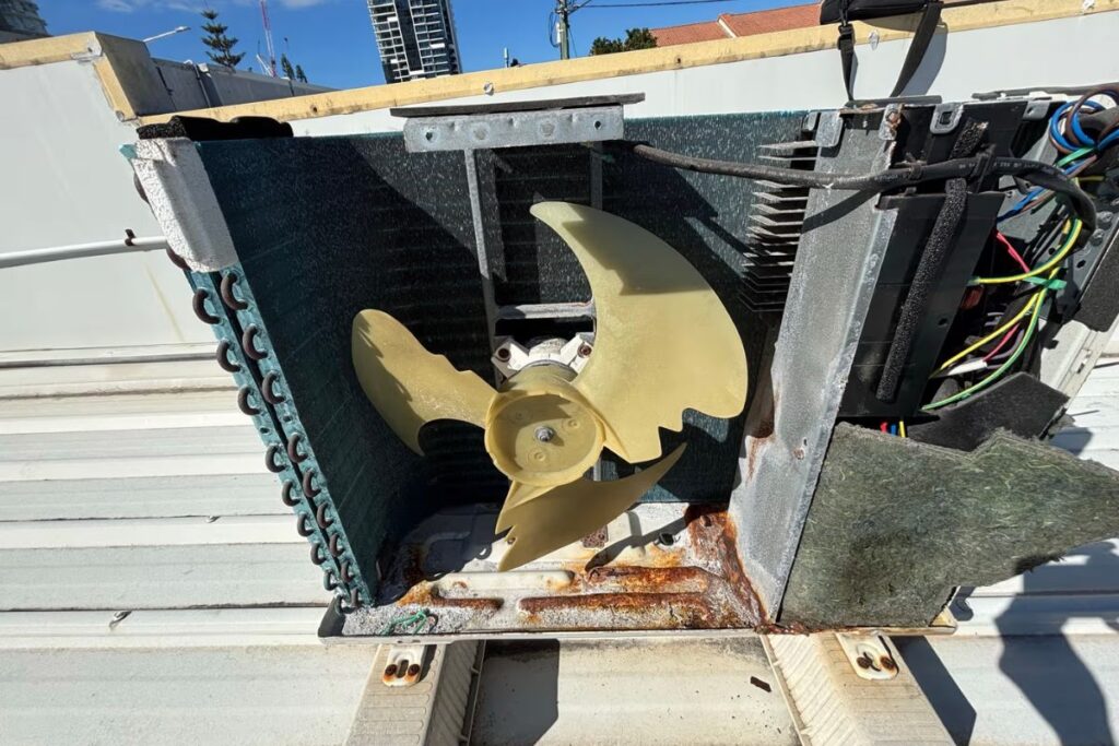 Salt-rusted rooftop air conditioner condenser and coil above the Gold Coast coast — rust treatment air conditioning Gold Coast
