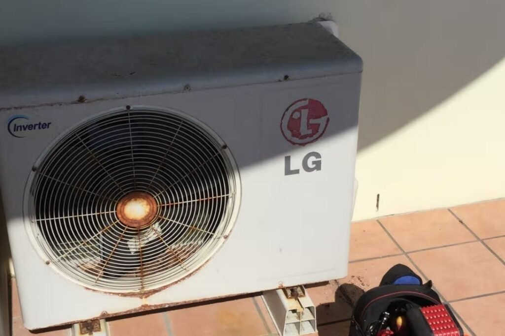 Technician assessing a rusted LG aircon on the Gold Coast for repair, rust treatment or upgrade