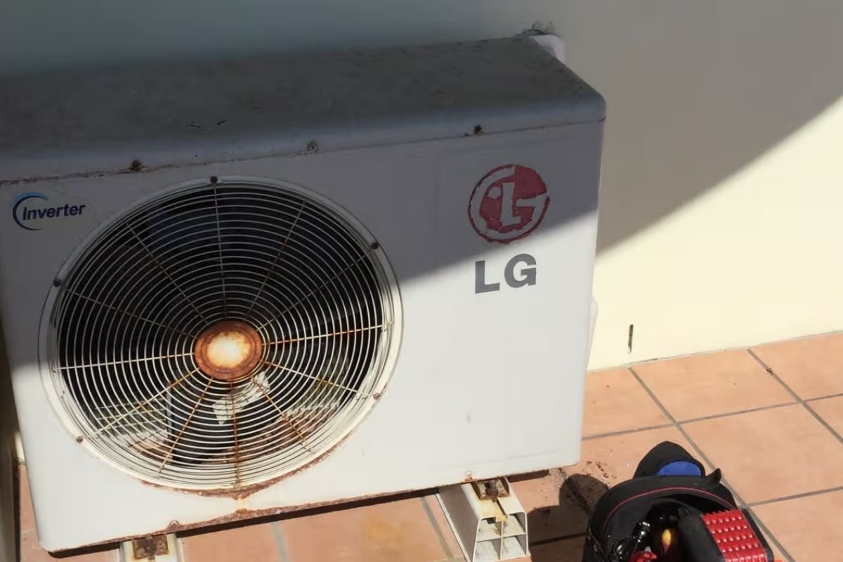 Technician assessing a rusted LG aircon on the Gold Coast for repair, rust treatment or upgrade