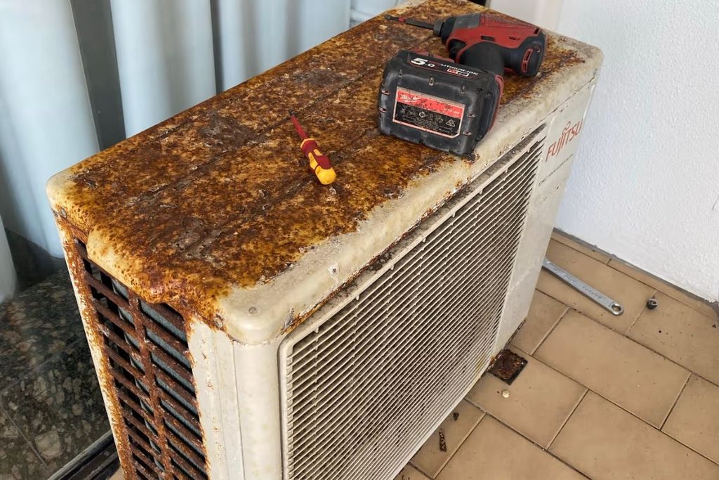 Rusted Fujitsu outdoor unit with tools on top during an air conditioning repair on the Gold Coast