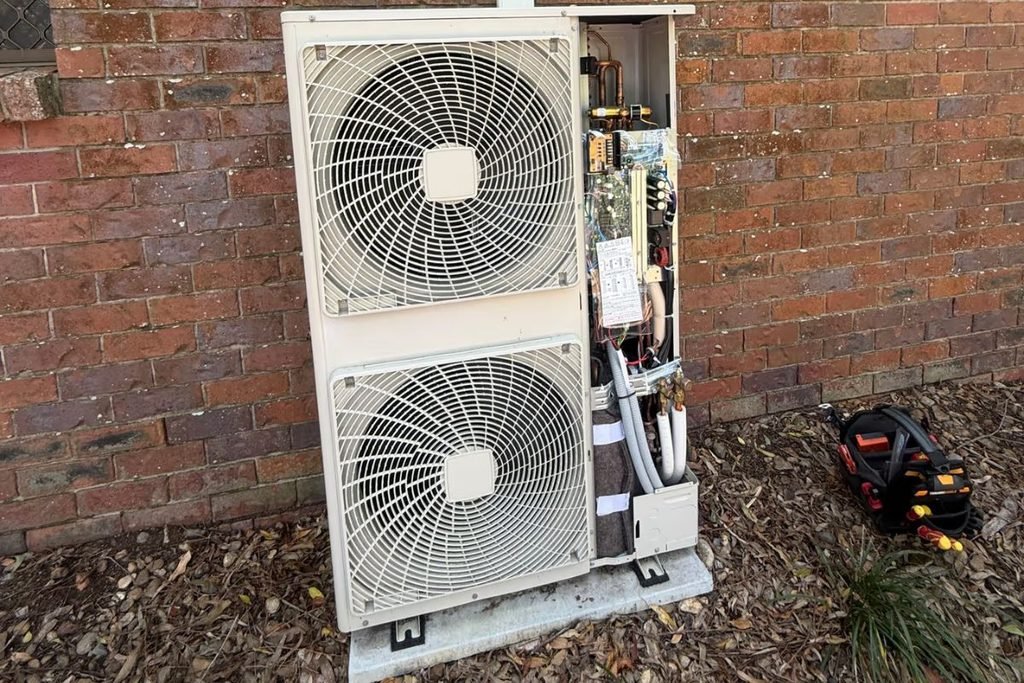 Ducted air conditioning maintenance on a Gold Coast outdoor unit with the service panel open