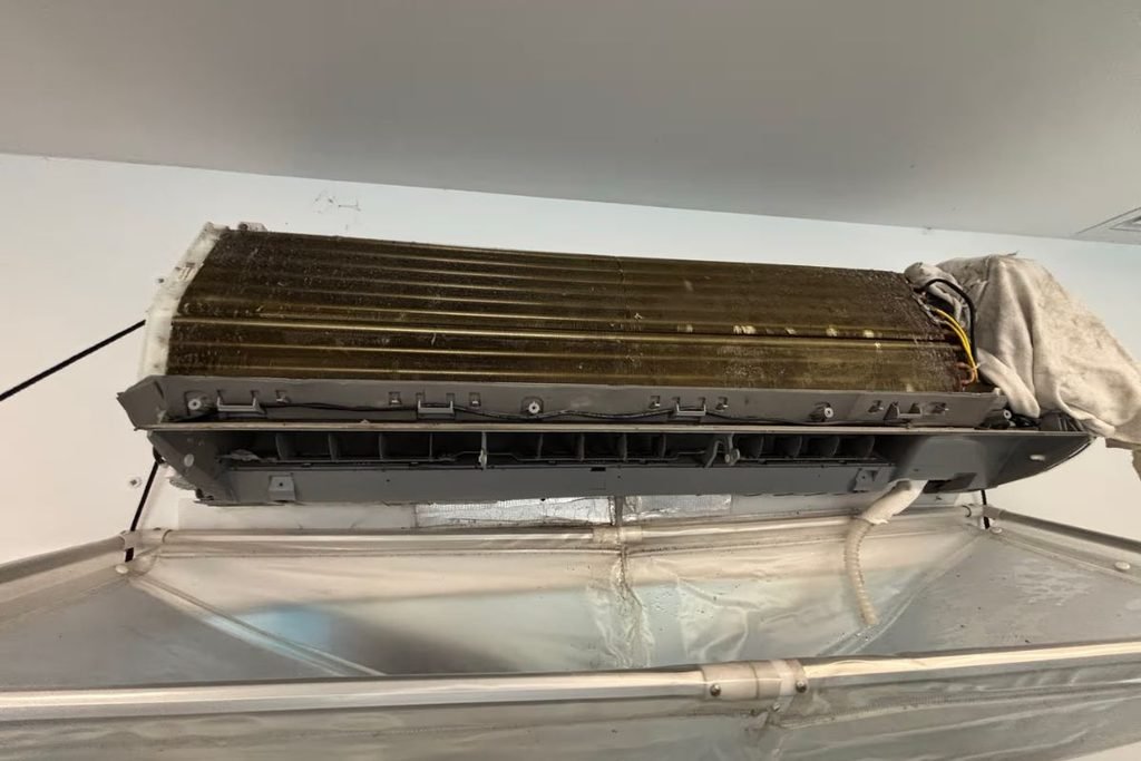 Aircon hydro clean Gold Coast: split system coil being washed with a drainage bag fitted