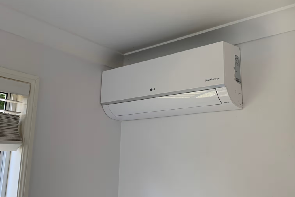 LG Smart Inverter reverse cycle split system mounted in the corner of a white bedroom, ready to set for air conditioning on the Gold Coast