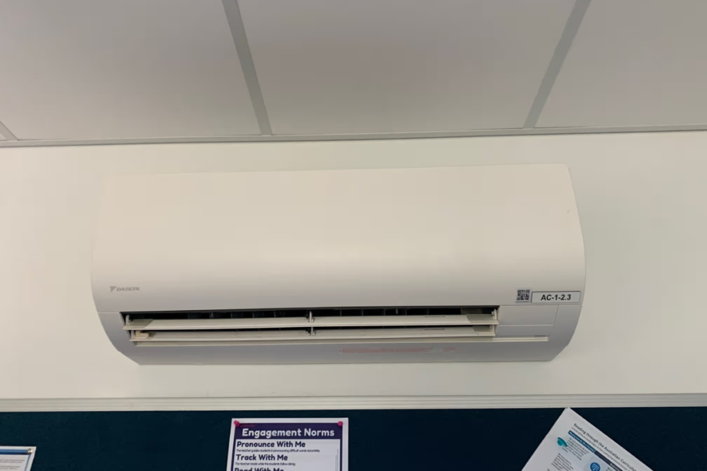Daikin wall-mounted split system above a noticeboard, commercial air conditioning on the Gold Coast for spring temperature swings